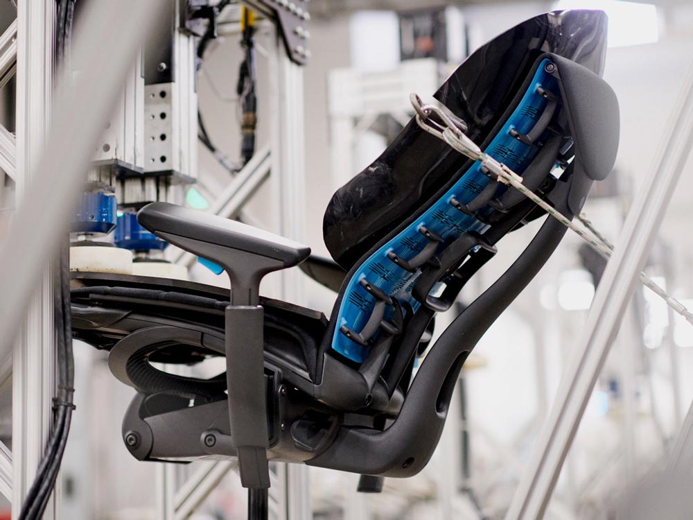 En Embody Gaming Chair, vist fra siden, i en testmaskine på Herman Millers produktionssted.